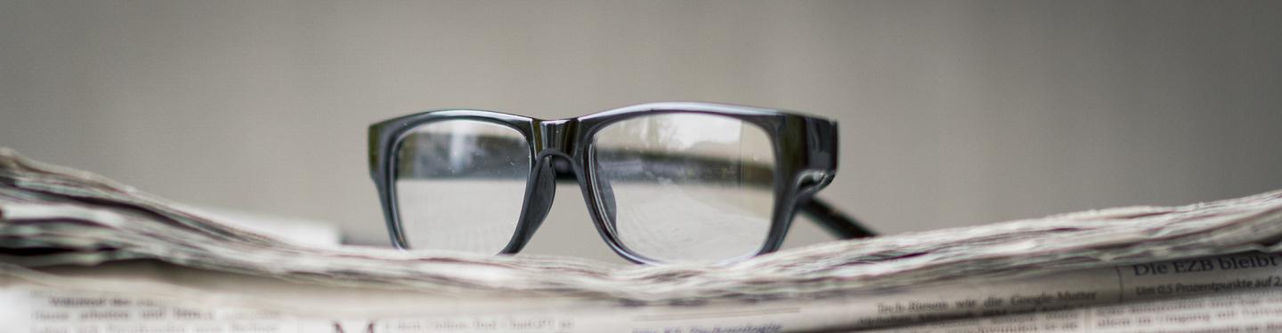 Brille auf Zeitschriftenstapel