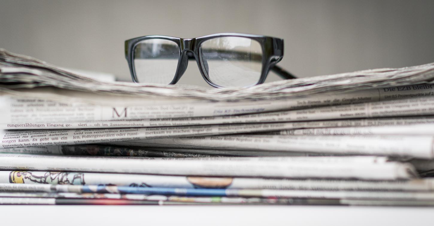 Brille auf Zeitschriftenstapel