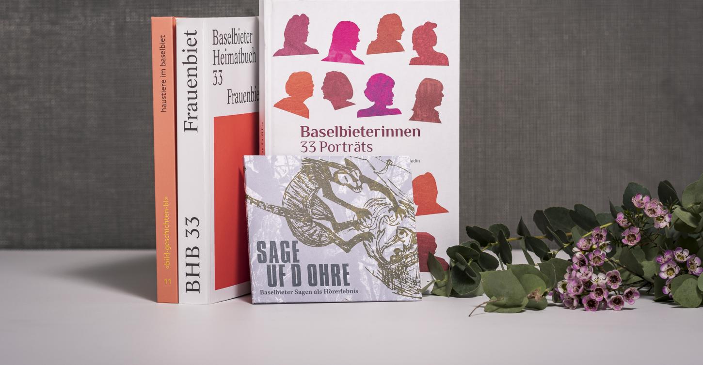 Einige Verlagsneuheiten auf Tisch aufgestellt, mit Blumen